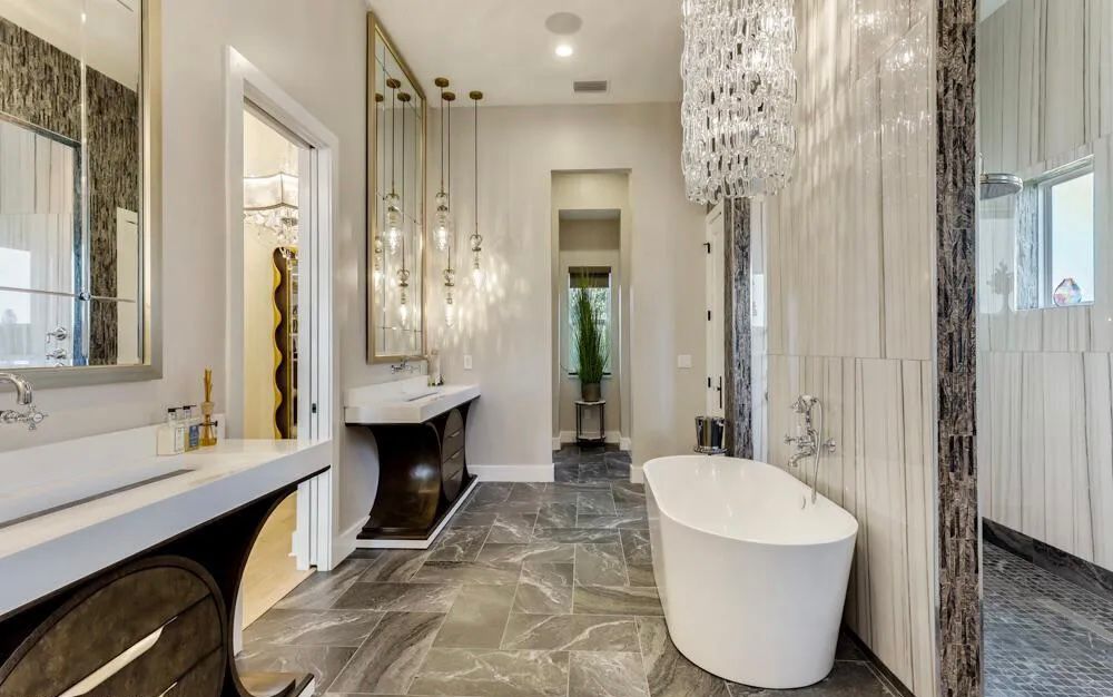 Finished primary bathroom with freestanding tub, dual pendant lighting, and custom stone detailing.