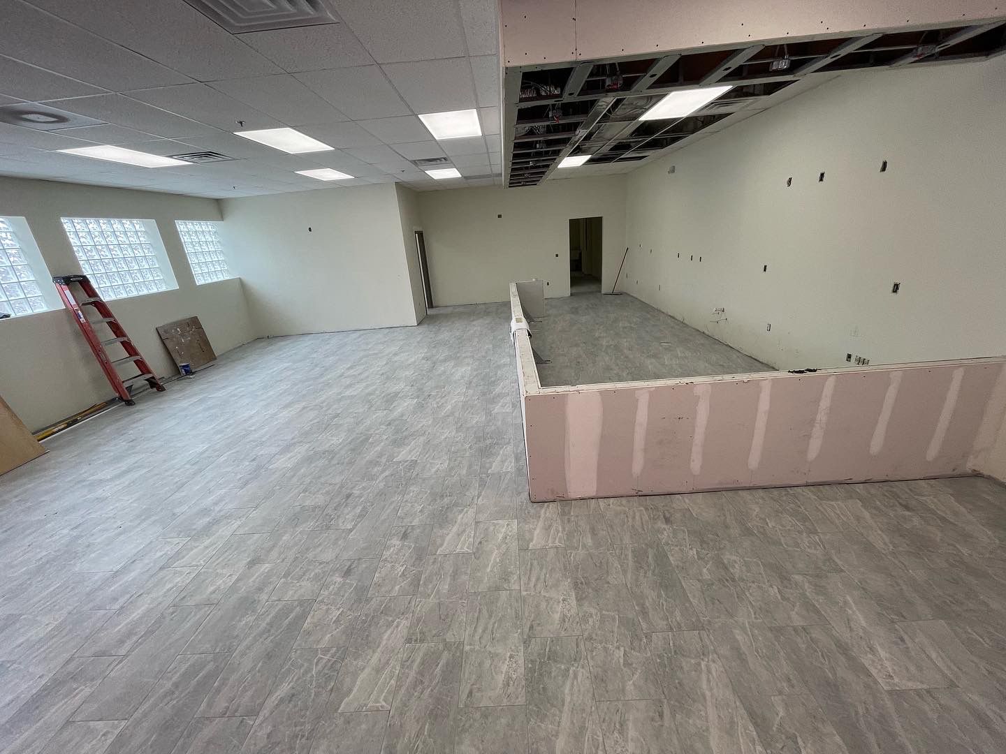 Retail construction buildout in progress with framed openings and work zones prepared for finishing.