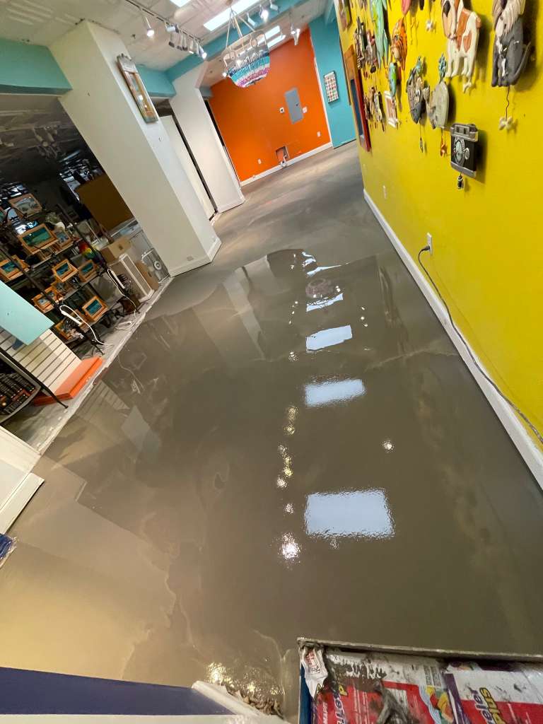 Finished retail showroom floor during commercial closeout with glossy surface installation.