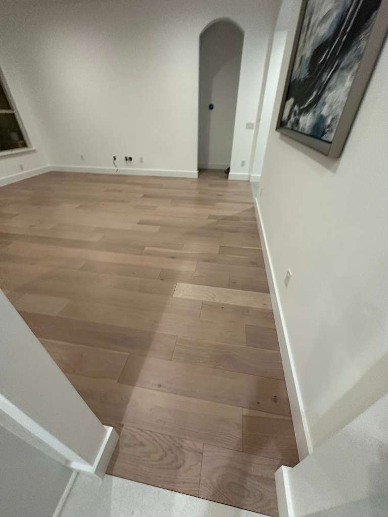 Herringbone wood flooring and clean trim transitions inside a finished residence.