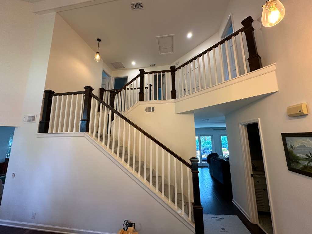 Finished staircase with dark wood railings inside a newly completed residence.