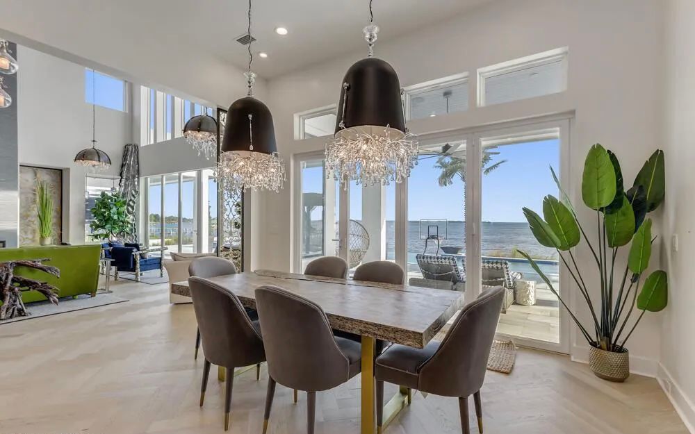 Dining area facing the water with dark pendants and direct connection to the great room.