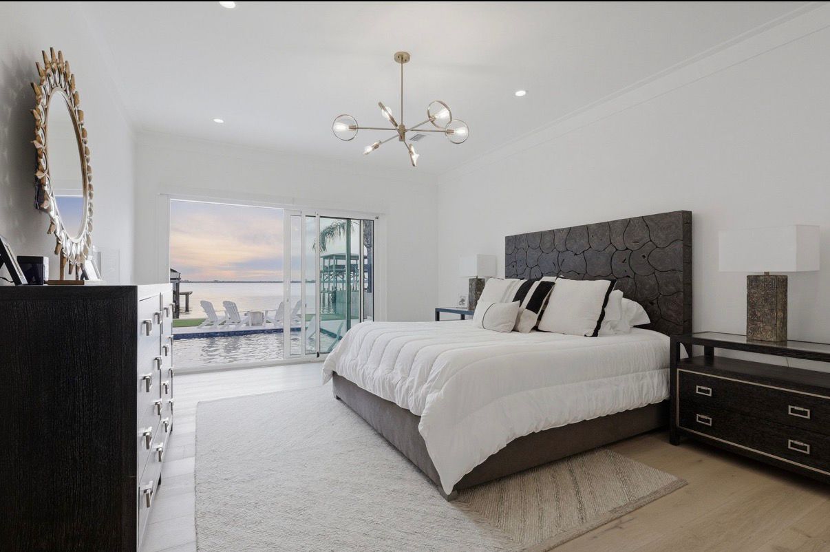 Primary bedroom with water view and direct connection to the pool deck.